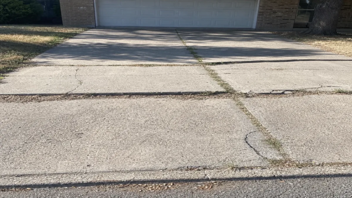 Black clay soil cracked concrete driveway Mesquite Texas Dallas County gumbo clay shrink-swell drought heaving residential