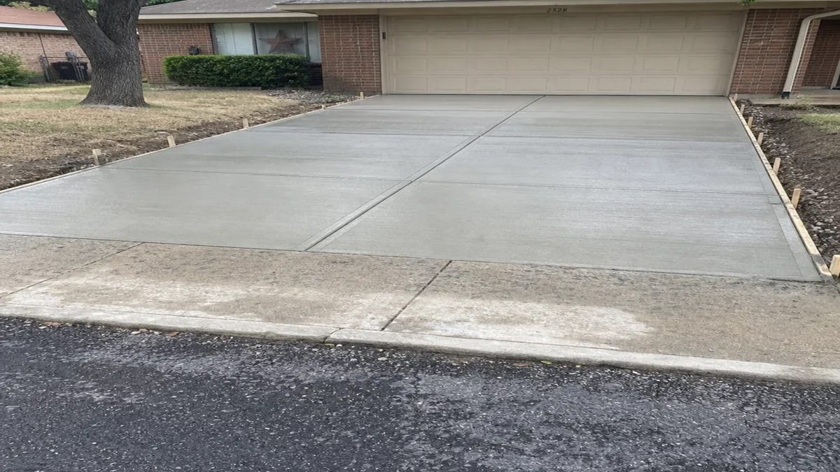 Freshly finished private concrete driveway Mesquite Texas Dallas County residential curb and garage separate from street