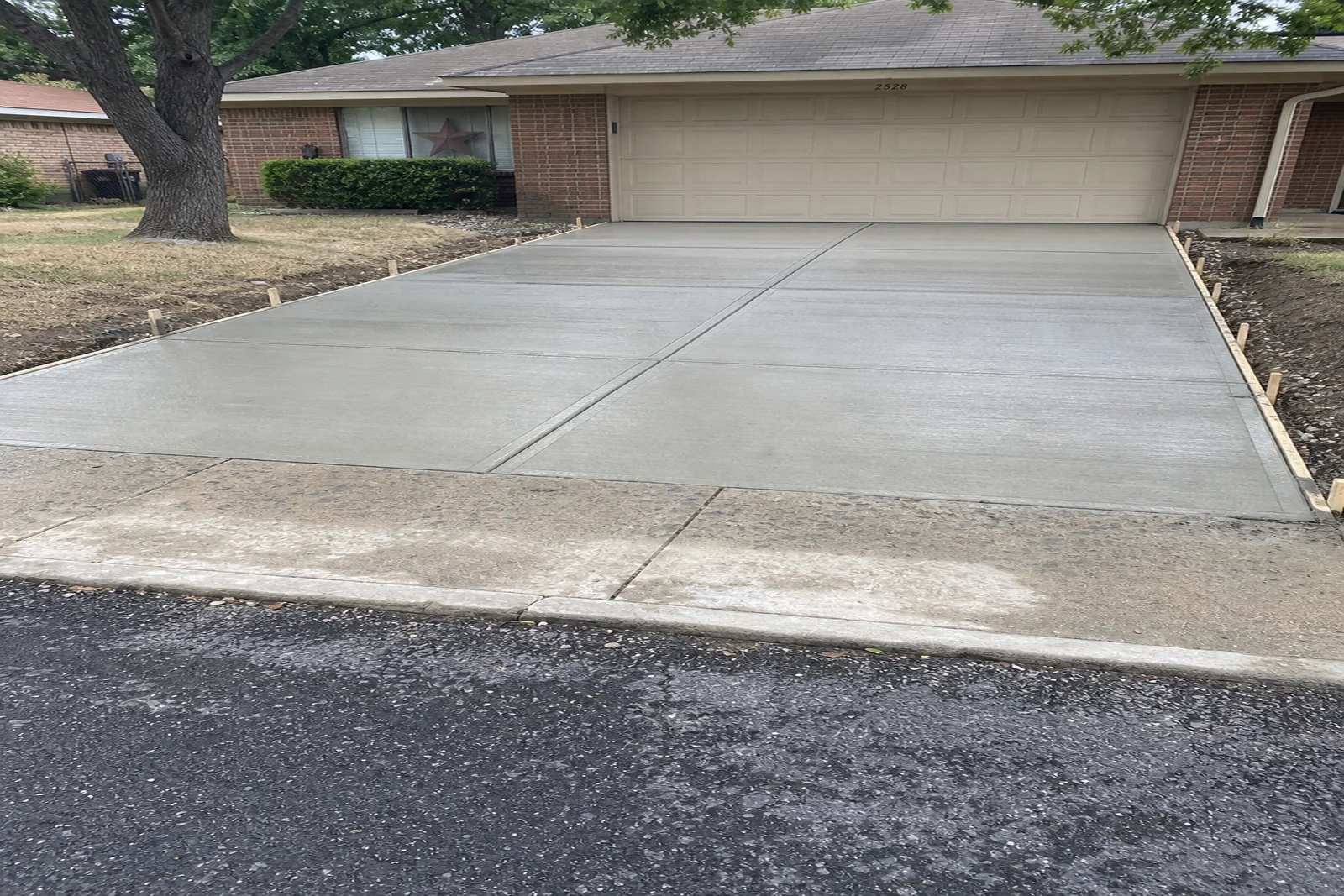 Freshly finished private concrete driveway Mesquite Texas Dallas County residential curb and garage separate from street