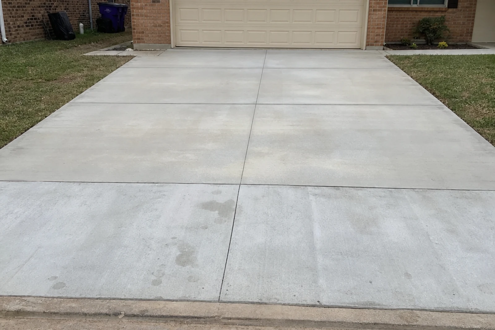 Realistic iPhone photo of finished private concrete driveway Mesquite Texas garage curb apron separate from asphalt street